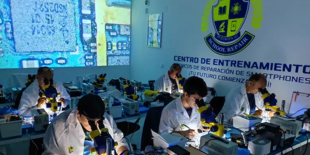 Técnico reparando un teléfono móvil en un taller profesional